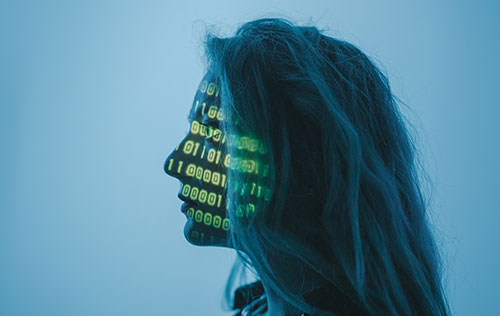 Photo of woman with code projecting onto face